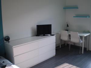 - une chambre avec une commode et une télévision dans l'établissement Studio Beaulieu, à Rennes