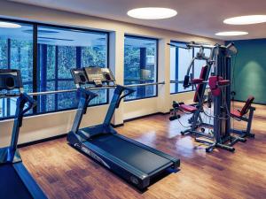 a gym with two treadmills and two exercise bikes at Mercure Iguazu Hotel Iru in Puerto Iguazú