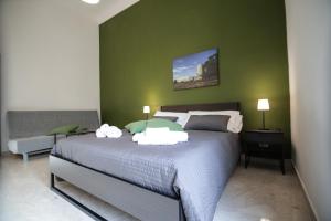 a bedroom with a large bed and a green wall at Niria in Ragusa