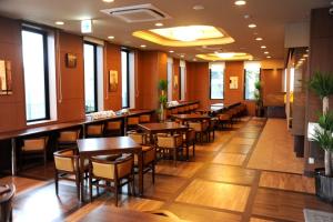 a restaurant with wooden floors and tables and chairs at Hotel Route-Inn Ena in Ena