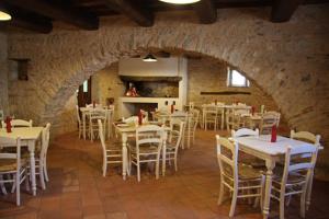 un comedor con mesas blancas y sillas blancas en FonteAntica Agriturismo, en Norcia