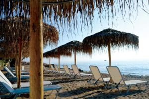 a row of chairs and umbrellas on a beach at Xanthippi Hotel in Souvala