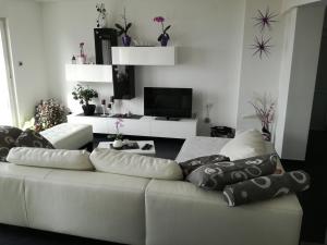 a living room with a white couch with pillows on it at Apartment Andro in Dramalj