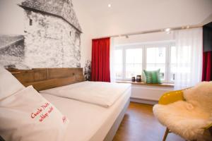 a bedroom with a bed and a chair and a window at bei Kliewe im Westfälischen Hof in Beckum