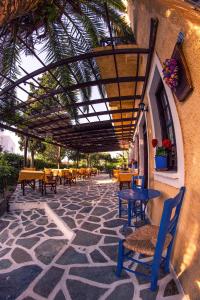 an outdoor patio with tables and chairs and awning at Vagia Traditional, Aegina Island in Vaia