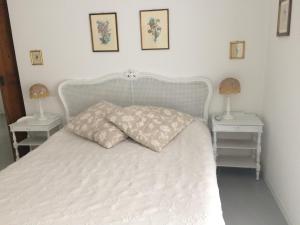 1 dormitorio con 1 cama blanca y 2 mesitas de noche en La Maison De Marie, en La Spezia