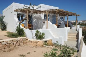 une maison blanche avec des escaliers en face de celle-ci dans l'établissement Apollon Koufonisia Studios, à Koufonisia