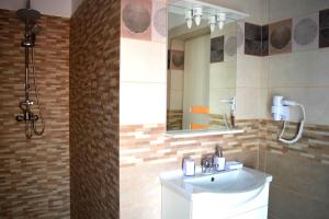 Apartament Liliac في بوخارست: حمام مع حوض ومرآة