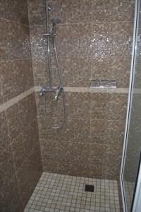 a shower in a bathroom with a tile floor at Apartment Vid na Krepost in Kamianets-Podilskyi