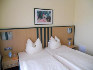 a bedroom with a white bed with two pillows at Apartments Aschheim in Aschheim