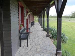 a porch of a building with benches on it at Walter Ranch in Kaskantyú