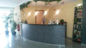 a lobby with a counter in a room with plants at Apartments Aschheim in Aschheim