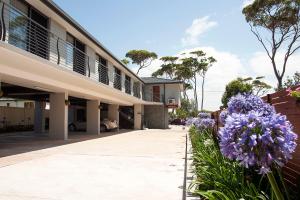 un edificio con fiori viola di fronte di Allure On Ocean Motel a Mollymook