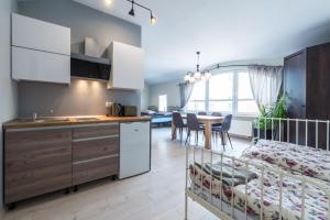 a kitchen and dining room with a crib in a room at Lake & City Apartments in Giżycko