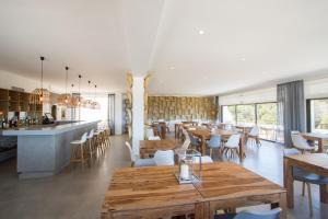 a restaurant with wooden tables and chairs and a bar at Casa Victoria Suites in Sant Josep de sa Talaia