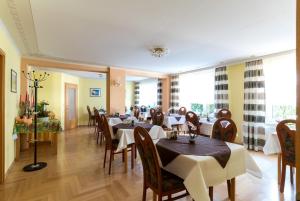 a dining room with tables and chairs and windows at Hotel Adler in Wismar