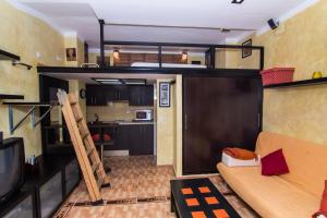 sala de estar con cama elevada y cocina en estudio marina puerto sherry, en El Puerto de Santa María
