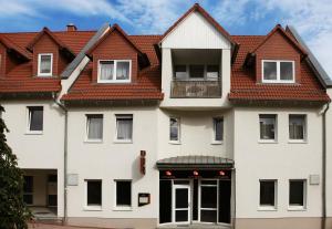 duży biały budynek z czerwonym dachem w obiekcie my CITY HOTEL w mieście Eisenberg