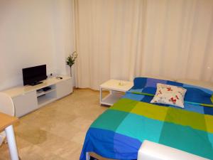 a bedroom with a colorful bed and a tv at Minimalist Loft Center by gms apartamentos in Córdoba