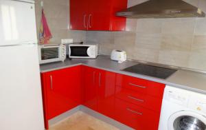a kitchen with red cabinets and a white microwave at Minimalist Loft Center by gms apartamentos in Córdoba