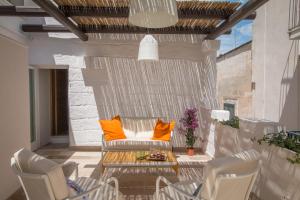 een patio met stoelen en een tafel met oranje kussens bij Casa Martina in Monopoli