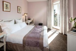Un dormitorio con una cama grande y una ventana en Le Cavendish, en Cannes