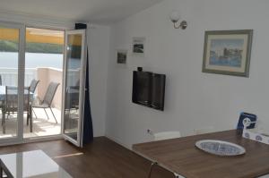 a living room with a table and a tv on a wall at Apartment Maria in Neum