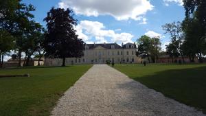 a stone path leading to a large building at Le Clos Du Presbytere in Puisseguin