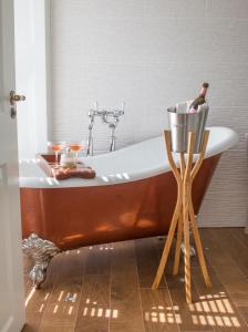 a bathroom with a tub with a bottle of champagne at Padstow Townhouse in Padstow +38 photos