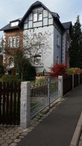 ein weißes und schwarzes Haus mit einem Zaun in der Unterkunft Ferienwohnung Rummel Selb in Selb