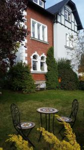 two tables and chairs in front of a house at Ferienwohnung Rummel Selb in Selb