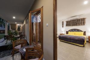 a bedroom with a bed and chairs in a room at Yuli's Homestay in Kuta Lombok