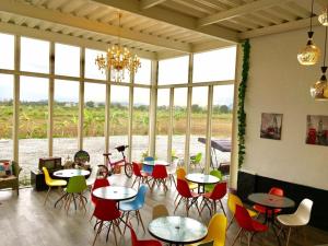 Un restaurante con mesas y sillas y un gran ventanal. en Mini Home B&B, en Kangle