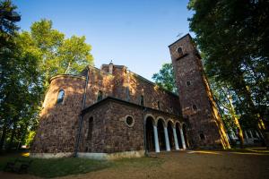 an old brick building with a tower on top of it at Bendegúz Villa in Balatonföldvár
