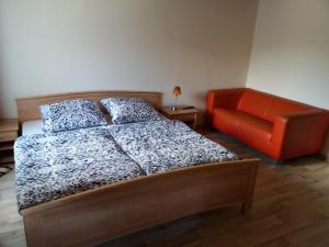 ein Schlafzimmer mit einem Bett und einem orangenen Stuhl in der Unterkunft Steeger Weinstube in Bacharach