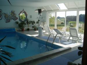 a swimming pool with white chairs and a swimming pool at Gästehaus Haagen in Bad Waltersdorf
