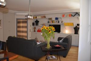 un soggiorno con divano e tavolo con vaso di fiori di Luci della città Palazzo San Matteo a Palermo