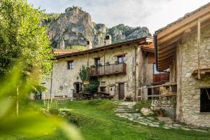 an old stone house with a mountain in the background at Locanda del Silenzio Hotel in Macra