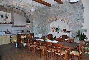 a kitchen with a wooden table and a stone wall at Mas la Torre in Palau-Saverdera