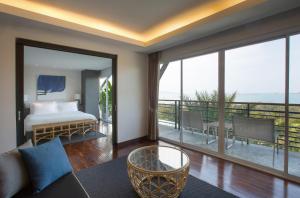 a bedroom with a bed and a view of the ocean at Mantra Samui Resort - Adults Only in Mae Nam