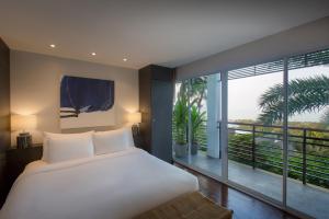a bedroom with a large bed and a large window at Mantra Samui Resort - Adults Only in Mae Nam