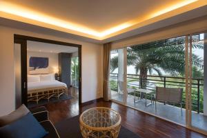 a living room with a bed and a balcony at Mantra Samui Resort - Adults Only in Mae Nam