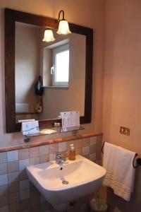 ein Badezimmer mit einem weißen Waschbecken und einem Spiegel in der Unterkunft L'Atelier di Pierflavio Gallina in La Morra