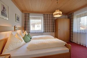 a bedroom with a large bed in a room with windows at Landhaus Horngacher in Ellmau