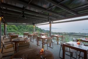 a restaurant with tables and chairs on a balcony at Mantra Samui Resort - Adults Only in Mae Nam