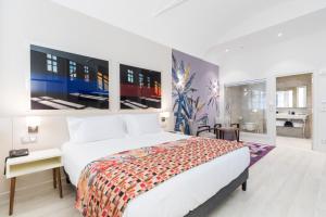 a bedroom with a large white bed and large windows at Palais Saleya Boutique Hôtel in Nice +38 photos