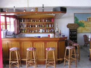 a kitchen with a bar with four stools at Knossos in Panormos Rethymno