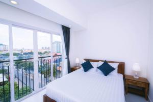 a bedroom with a bed and a large window at Sun Apartment in Phnom Penh