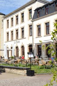 ein Gebäude mit Tischen und Stühlen davor in der Unterkunft Hotel Restaurant Le Paris in Mondorf-les-Bains