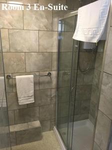 Un baño con ducha con puerta de cristal. en The Arches Guest House, en Whitby